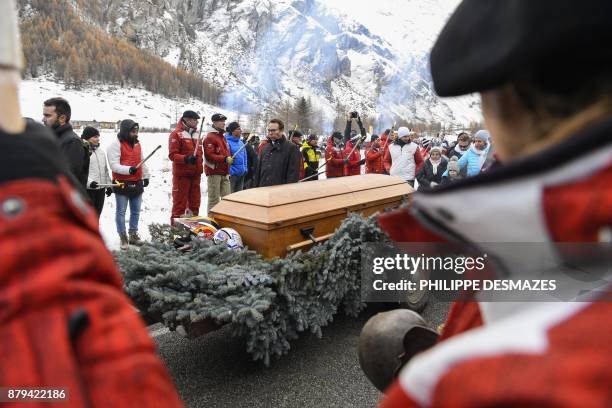 People stand along the road near the coffin of late French skier David Poisson during a ceremony in his memory in Peisey-Nancroix, in the French...