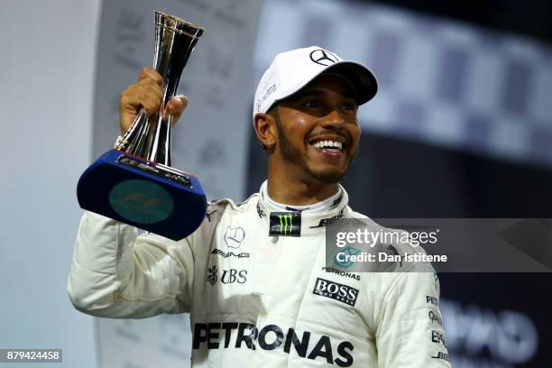 Second place finisher Lewis Hamilton of Great Britain and Mercedes GP celebrates with his trophy on the podium during the Abu Dhabi Formula One Grand...