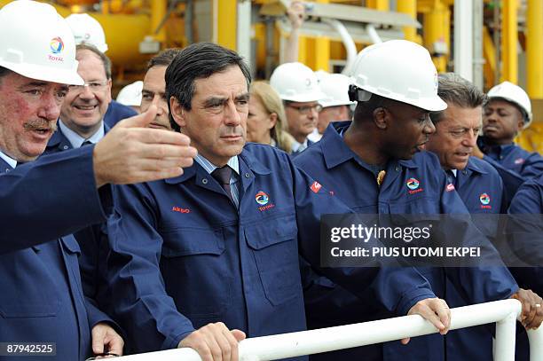 Executive director of Total Oil Francois Rafin talks to French Prime Minister Francois Fillon beside Rivers State Governor Rotimi Amaechi at the...