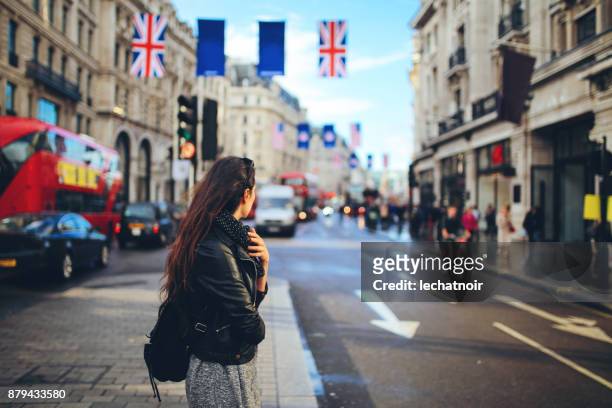 young woman crossing the street in central london - daily life at oxford street london stock pictures, royalty-free photos & images