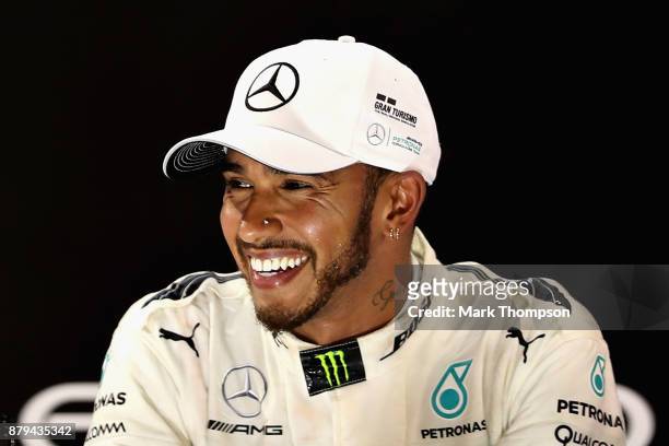 Second place finisher Lewis Hamilton of Great Britain and Mercedes GP celebrates with his trophy on the podium during the Abu Dhabi Formula One Grand...