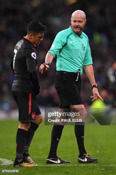 Referee Lee Mason interacts with Arsenal's Chilean striker Alexis Sanchez during the English Premier League football match between Burnley and...