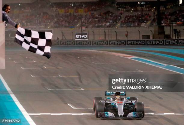 Mercedes' British driver Lewis Hamilton crosses the finish line during the Abu Dhabi Formula One Grand Prix at the Yas Marina circuit on November 26,...