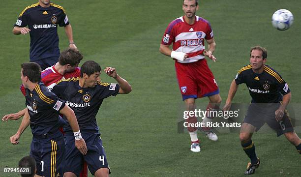 Drew Moor of the FC Dallas scores on a header flanked by Alan Gordon and Omar Gonzalez of the Los Angeles Galaxy at Pizza Hut Park on May 23, 2009 in...