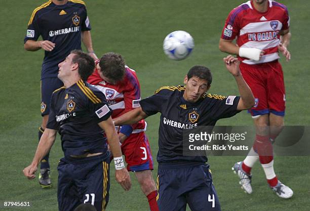 Drew Moor of the FC Dallas scores on a header flanked by Alan Gordon and Omar Gonzalez of the Los Angeles Galaxy at Pizza Hut Park on May 23, 2009 in...