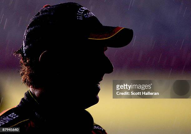 Mike Bliss, driver of the Miccosukee Indian Gaming & Resort Chevrolet, stands on the grid in a rain delay during the NASCAR Nationwide Series...
