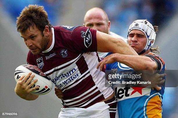 Josh Perry of the Sea Eagles attempts to break free from the tackle of Nathan Friend of the Titans during the round 11 NRL match between the Gold...