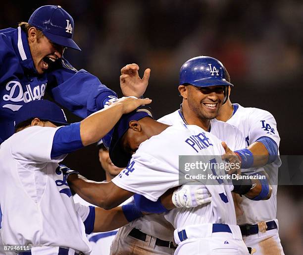 Juan Pierre of the Los Angeles Dodgers is congratulated by pitcher Clayton Kershaw catcher Russell Martin and Matt Kemp who scored the winning run...