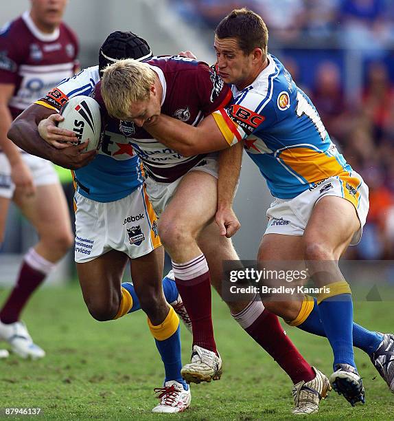 Shane Rodney of the Sea Eagles attempts to drive through the Titans defence during the round 11 NRL match between the Gold Coast Titans and the Manly...