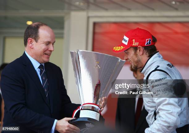 Jenson Button of Great Britain and Brawn GP is presented with the winners trophy by Prince Albert II of Monaco after his victory in the Monaco...