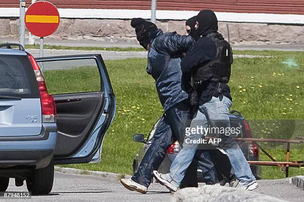 Police officers from the Swedish special forces escort one of the four robbers that tried to blow their way in to the cash courier company Loomis...