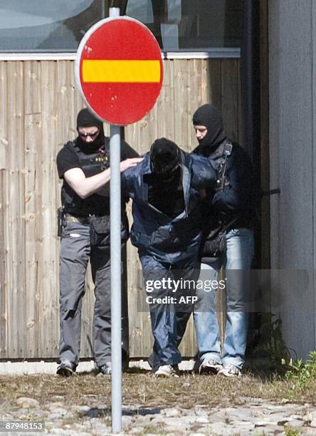 Police officers from the Swedish special forces escort one of the four robbers that tried to blow their way in to the cash courier company Loomis...