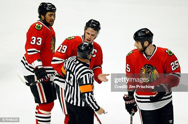 Dustin Byfuglien, Jonathan Toews and Cam Barker of the Chicago Blackhawks plead their case to referee Dan O'Halloran against the Detroit Red Wings...