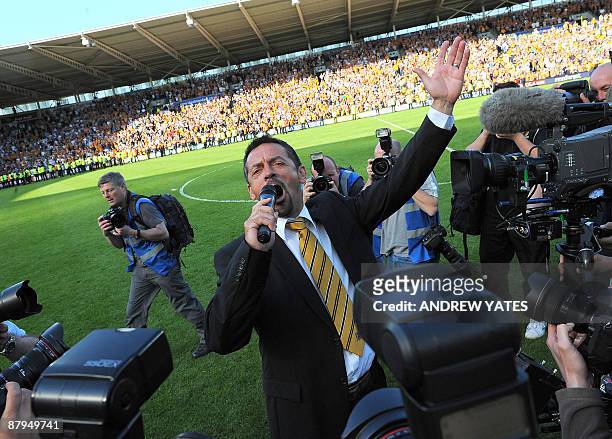 Hull City manager Phil Brown celebrates by singing with the supporters on the pitch after his team avoid religation after the English Premier League...