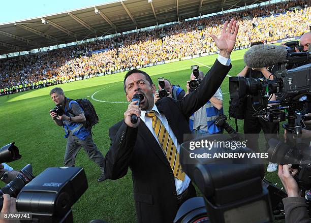 Hull City manager Phil Brown celebrates by singing with the supporters on the pitch after his team avoid religation after the English Premier League...