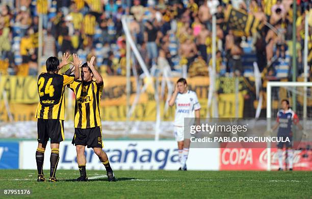 Penarol's player Antonio Pacheco celebrates with his teammate Maximiliano Bajter after scoring the first goal of his team during the Uruguayan...