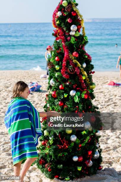 young girl on australian beach with christmas tree - people celebrate christmas at bondi beach stock-fotos und bilder