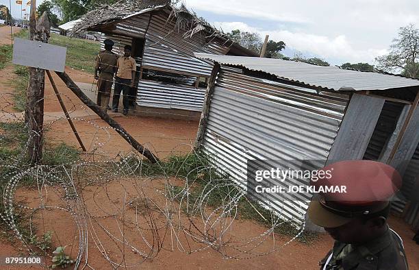 Sri Lankan soldiers stand guard an entrance during United Nations Secretary-General Ban Ki-moon's visit to Menik Farm refugee camp in Cheddikulam on...