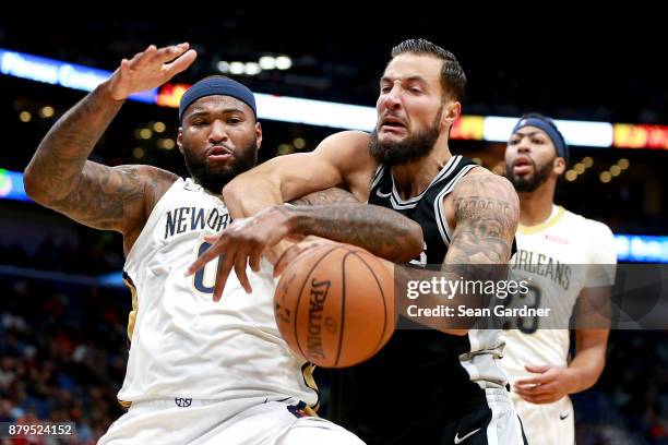 DeMarcus Cousins of the New Orleans Pelicans scrambles for a loose ball with Joffrey Lauvergne of the San Antonio Spurs during the first half of a...