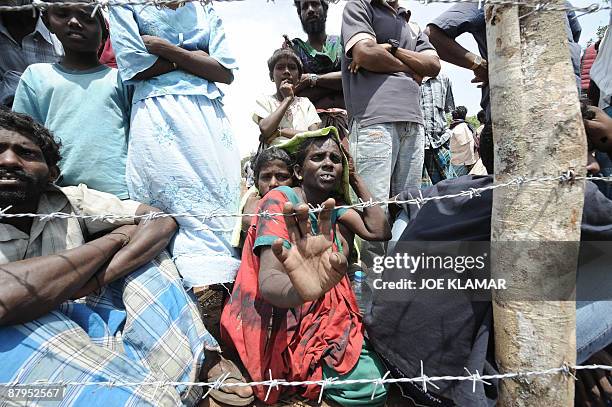 Internally displaced Sri Lankan people gather behind barbed wire between tents during a visit by United Nations Secretary-General Ban Ki-moon at...