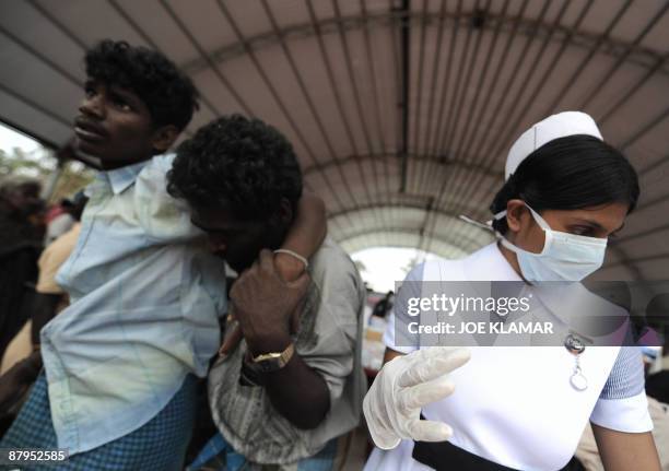 Nurse prepares a needle for patients at a makeshift hospital for internally displaced Sri Lankan people during a visit by United Nations...