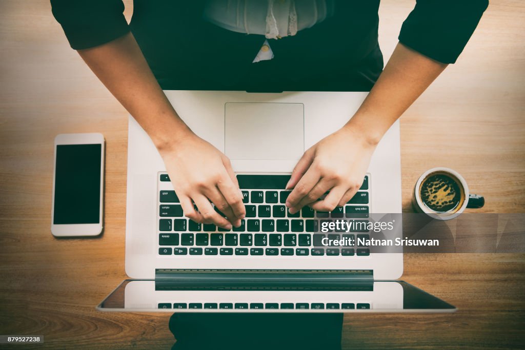 Woman using laptop and smartphone.