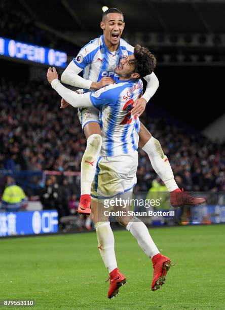 Tom Ince and Christopher Schindler of Huddersfield Town celebrate after Nicolas Otamendi of Manchester City scored the first own goal during the...