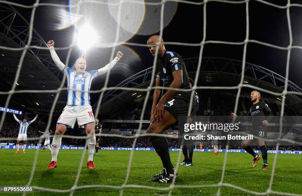 Aaron Mooy of Huddersfield Town celebrates after Nicolas Otamendi of Manchester City scored the first own goal as Vincent Kompany of Manchester City...