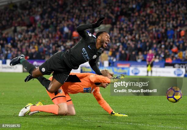 Raheem Sterling of Manchester City and Jonas Lossl of Huddersfield Town clash during the Premier League match between Huddersfield Town and...