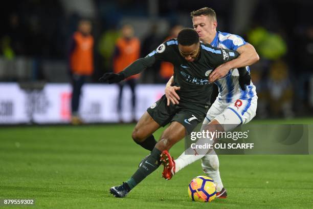 Manchester City's English midfielder Raheem Sterling is marked by Huddersfield Town's English midfielder Jonathan Hogg during the English Premier...