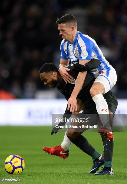 Raheem Sterling of Manchester City is tackled by Jonathan Hogg of Huddersfield Town during the Premier League match between Huddersfield Town and...