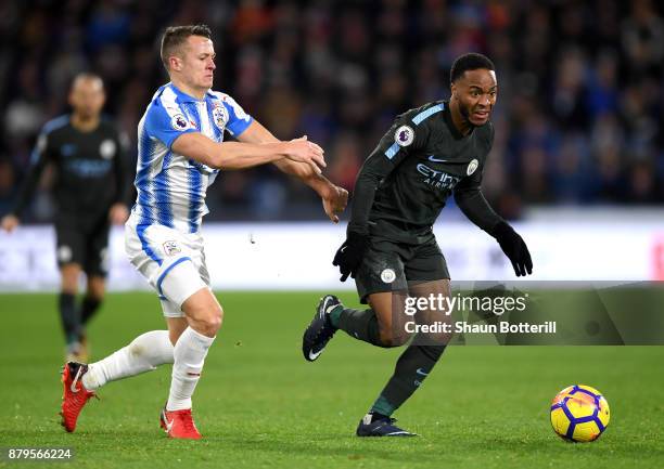 Raheem Sterling of Manchester City is tackled by Jonathan Hogg of Huddersfield Town during the Premier League match between Huddersfield Town and...