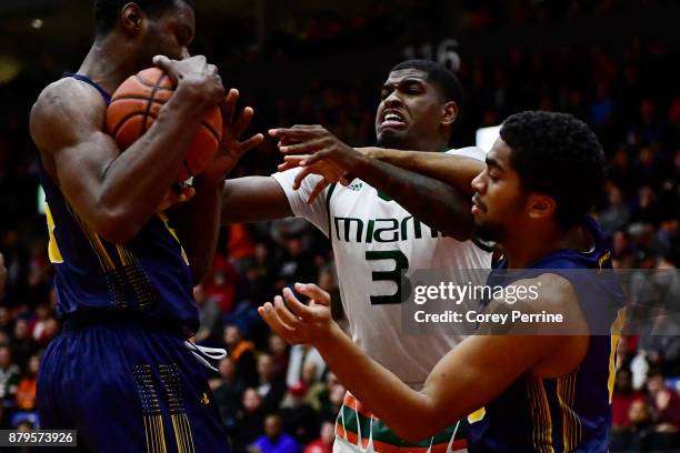 Anthony Lawrence II of the Miami Hurricanes fights for the ball from Tony Washington and Pookie Powell of the La Salle Explorers during the second...