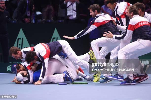 France's Lucas Pouille celebrates with his teammates after winning his singles rubber 5 match against Belgium's Steve Darcis at the Davis Cup World...