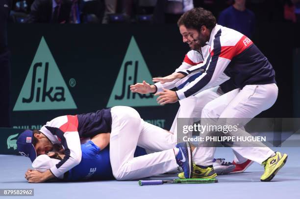 France's Lucas Pouille celebrates with his teammates after winning his singles rubber 5 match against Belgium's Steve Darcis at the Davis Cup World...