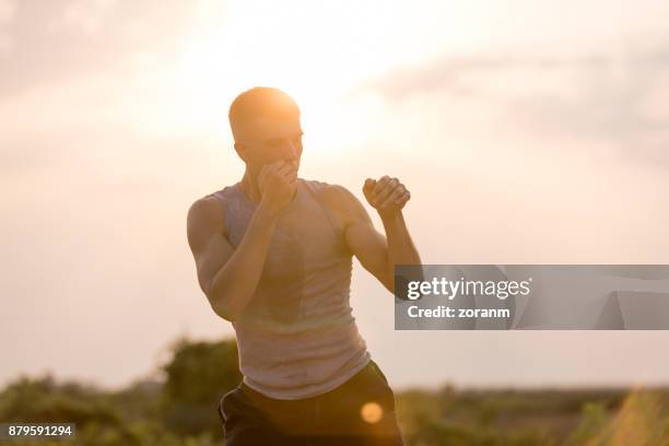 man practicing shadow boxing outdoors - tai chi shadow stock pictures, royalty-free photos & images