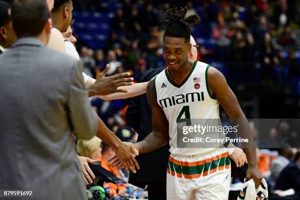 Lonnie Walker IV of the Miami Hurricanes high-fives teammates before going to the bench in the final seconds during the second half at Santander...