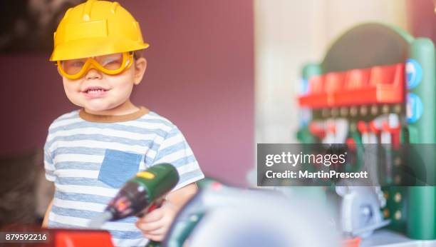 playing with his construction toys - boy in hard hat stock pictures, royalty-free photos & images