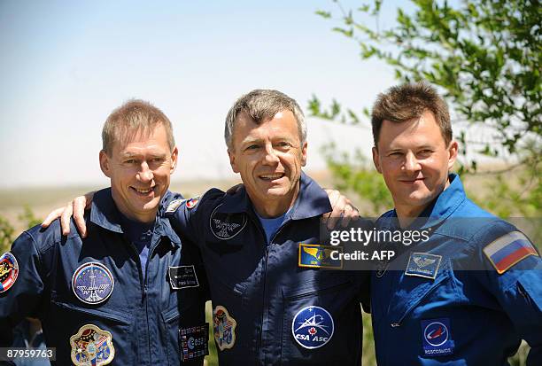 European Space Agency astronaut Frank De Winne of Belgium , Canadian astronaut Robert Thirsk and Russian cosmonaut Roman Romanenko pose for the press...