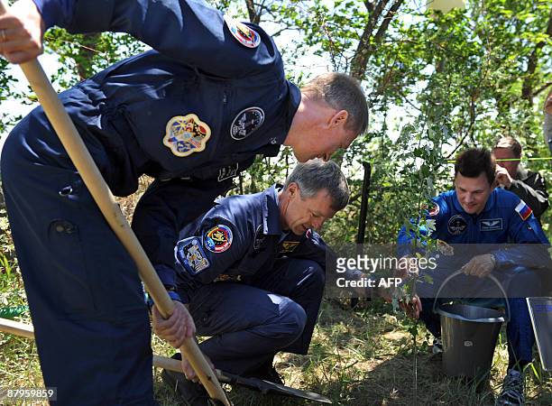 European Space Agency astronaut Frank De Winne of Belgium , Canadian astronaut Robert Thirsk and Russian cosmonaut Roman Romanenko plant a tree at...