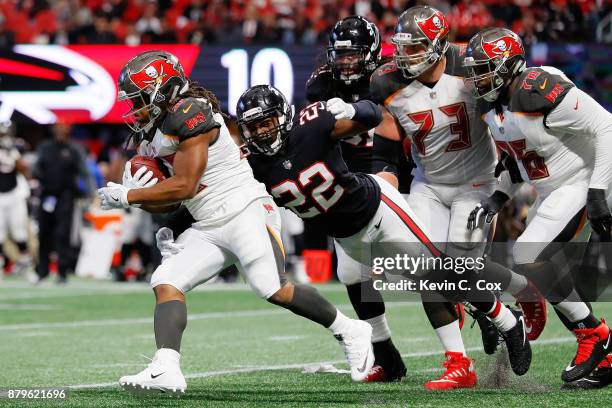 Jacquizz Rodgers of the Tampa Bay Buccaneers outruns a tackle by Keanu Neal of the Atlanta Falcons during the first half at Mercedes-Benz Stadium on...