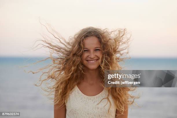 beautiful hair blowing in the breeze - curly blonde hair stock pictures, royalty-free photos & images