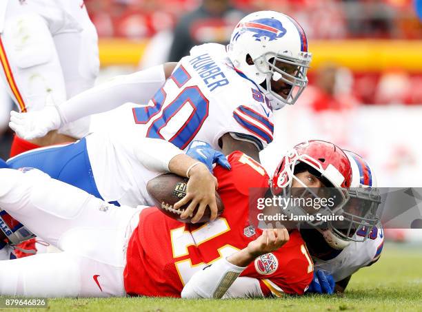 Quarterback Alex Smith of the Kansas City Chiefs is tackled by Jerry Hughes and outside linebacker Ramon Humber of the Buffalo Bills after scrambling...