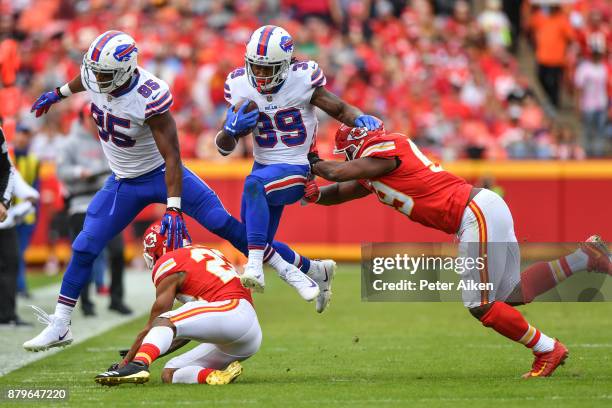 Running back Travaris Cadet of the Buffalo Bills hurdles over the tackle attempt of Marcus Peters and inside linebacker Reggie Ragland of the Kansas...