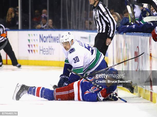 Brendan Gaunce of the Vancouver Canucks and Steven Kampfer of the New York Rangers get tangled up during the first period at Madison Square Garden on...