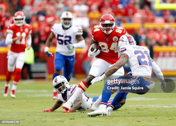 Tight end Demetrius Harris of the Kansas City Chiefs carries the ball after making a catch as defensive back Leonard Johnson of the Buffalo Bills...