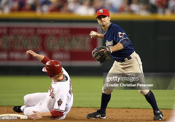 Infielder Chris Burke of the San Diego Padres gets the force out on Mark Reynolds of the Arizona Diamondbacks at second base during the major league...