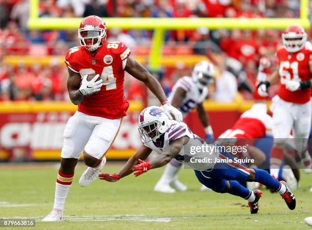 Tight end Demetrius Harris of the Kansas City Chiefs carries the ball after making a catch as defensive back Leonard Johnson of the Buffalo Bills...