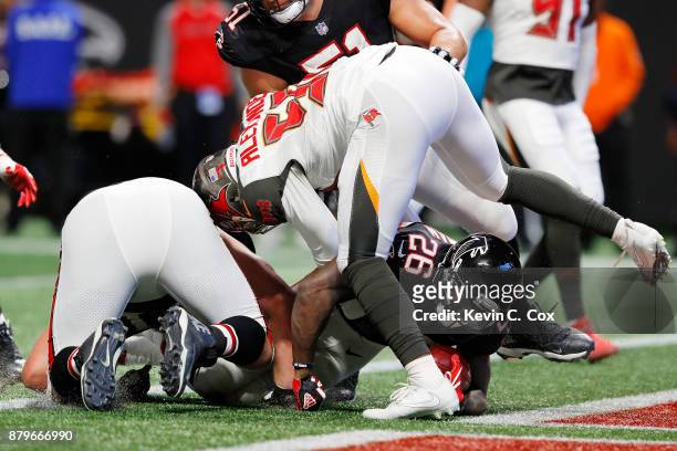Tevin Coleman of the Atlanta Falcons slips underneath Kwon Alexander of the Tampa Bay Buccaneers for a touchdown during the second half at...