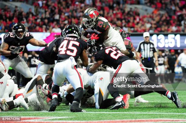 Peyton Barber of the Tampa Bay Buccaneers jumps over the pile to score a touchdown during the second half against the Atlanta Falcons at...